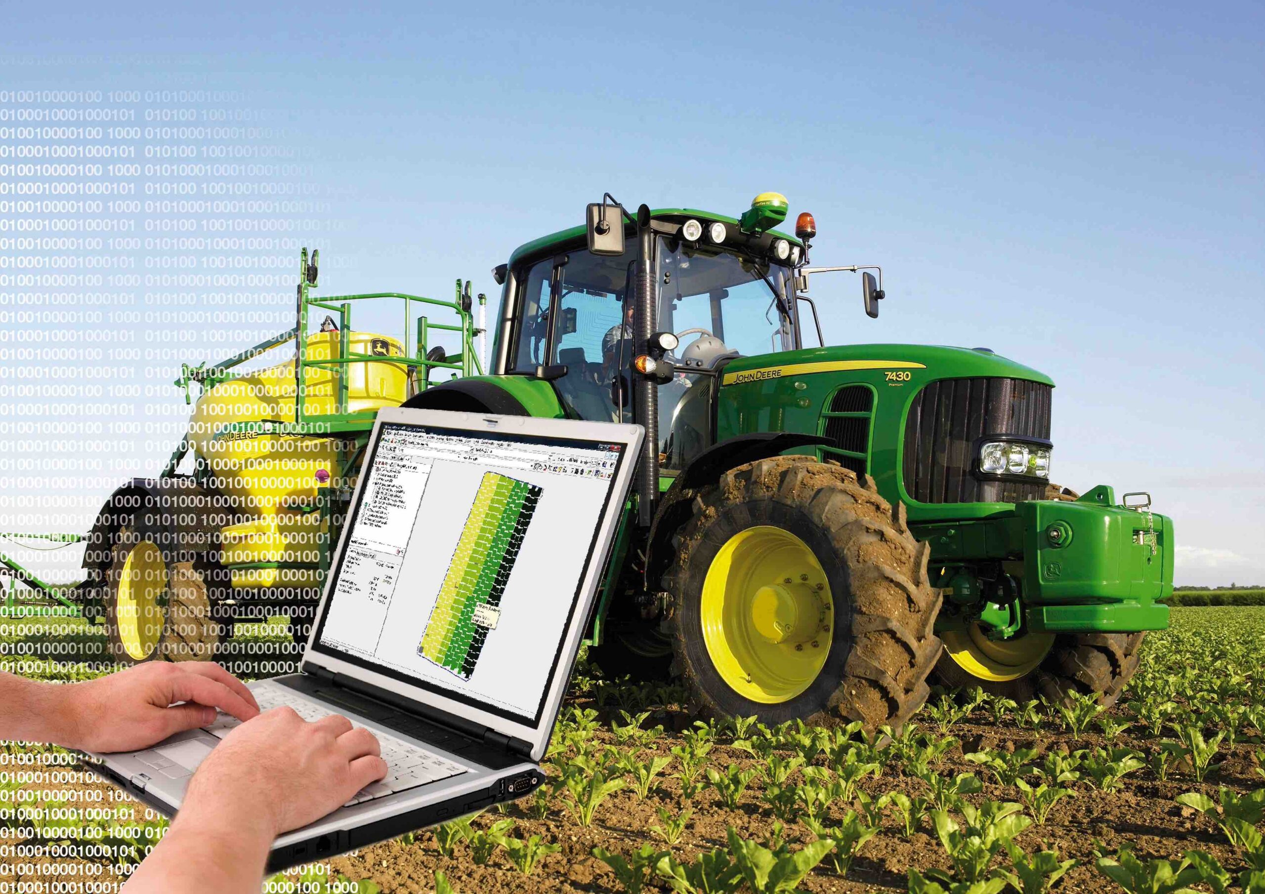 Laptop egy traktor előterében, a képernyőn NEXT Farming Pro látható