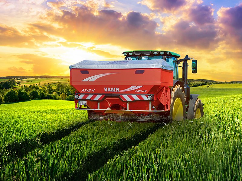 Traktor műtrágyaszóróval egy búzatáblában